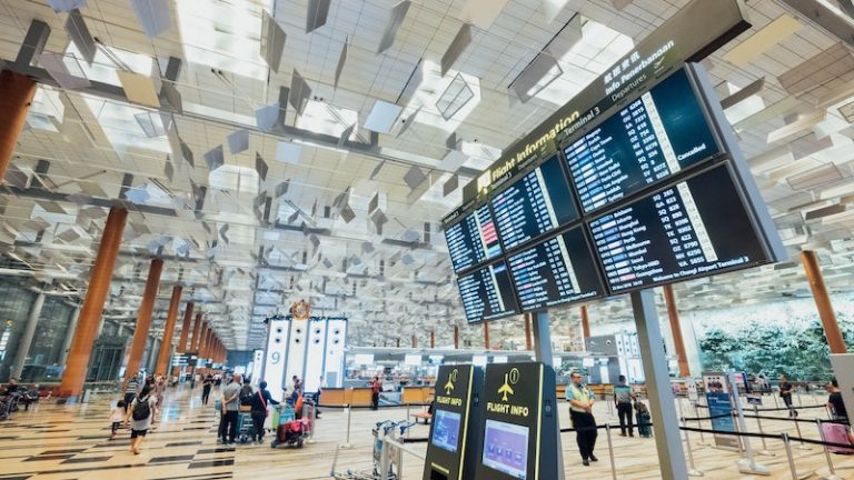 vliegveld met schermen en reizigers