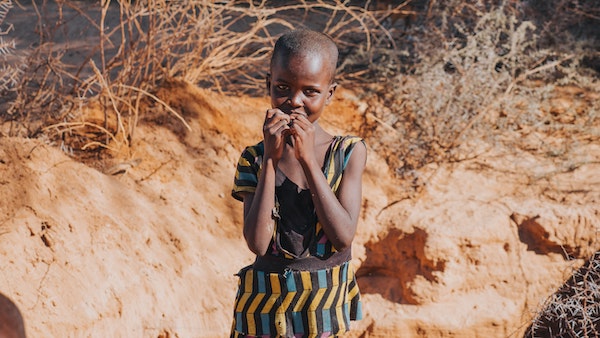 Kind tussen zand op school in Kenia
