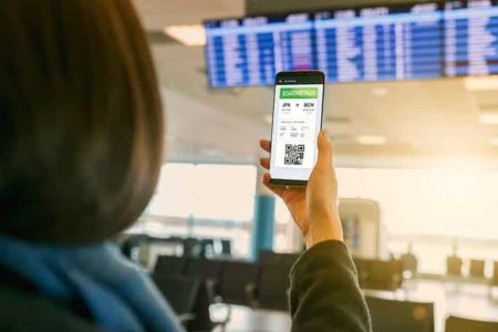 vrouw houdt haar telefoon vast met het e-visum op het vliegveld